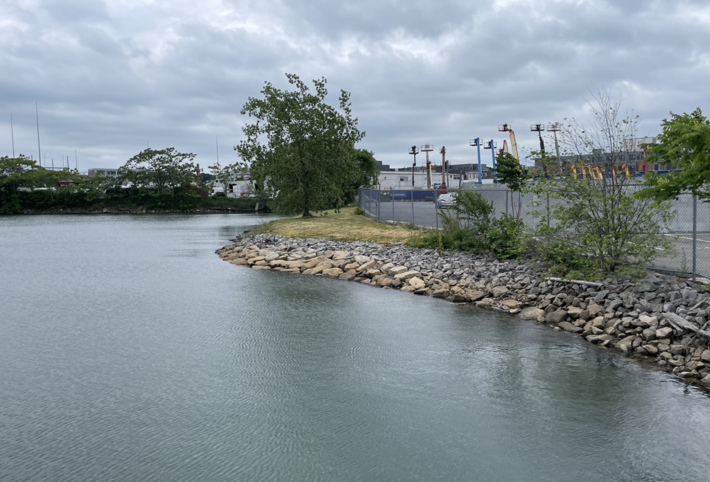 existing conditions of a rocky shoreline looking from Pappas Way towards the Eversource substation